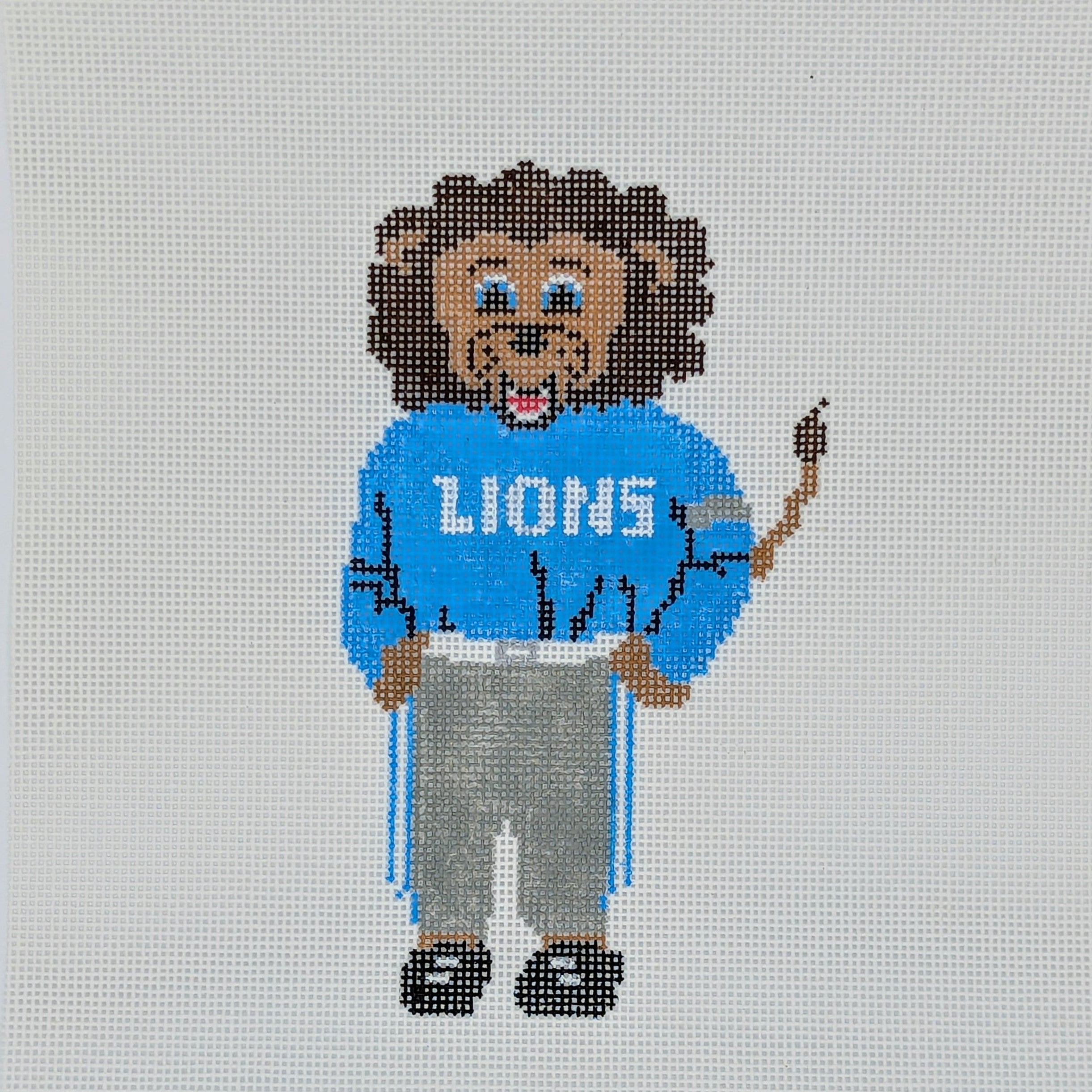 Needlepoint lion wearing a 'LIONS' sweater on a white background with 'The Needlepoints North' branding.