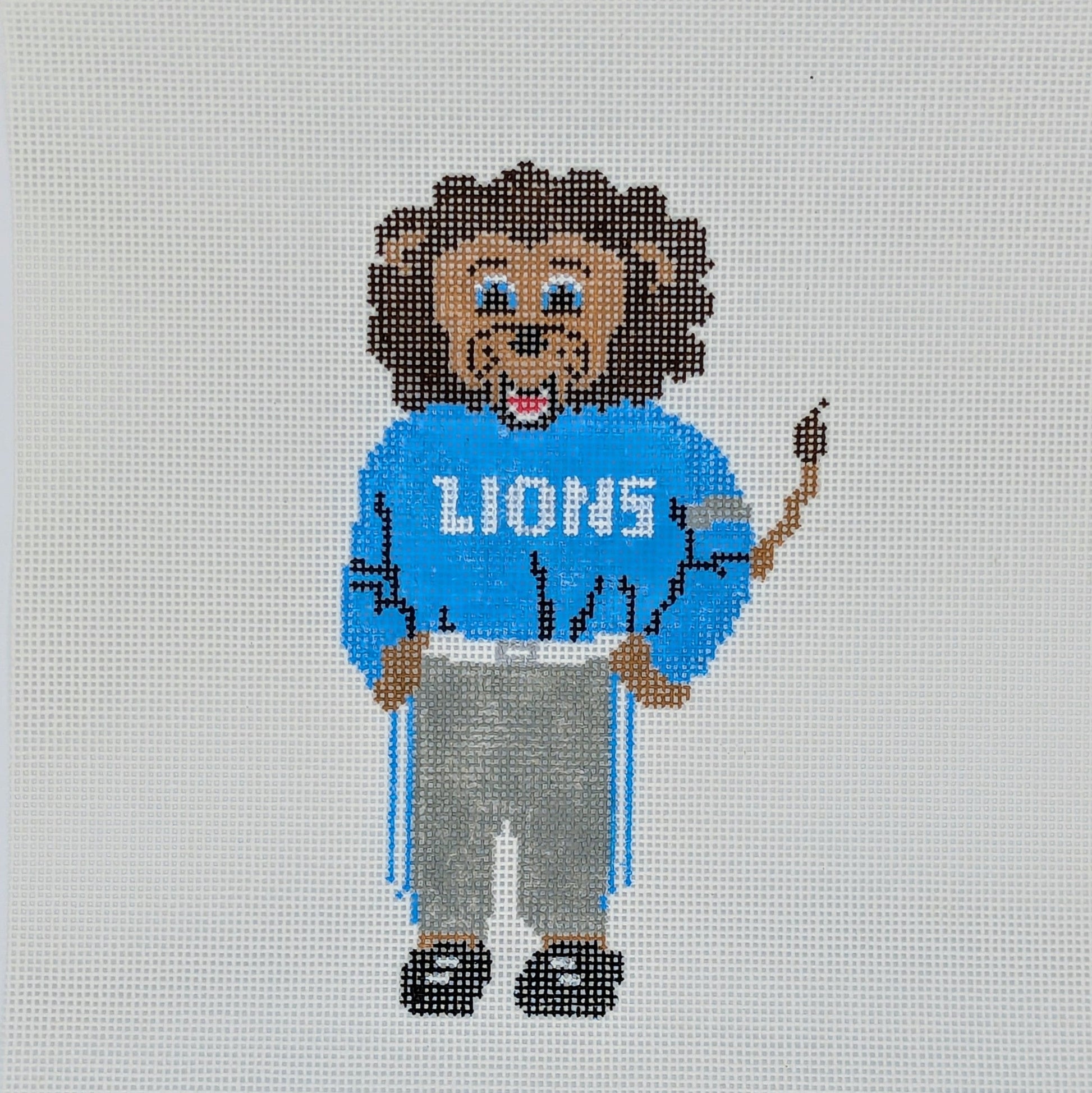 Needlepoint lion wearing a 'LIONS' sweater on a white background with 'The Needlepoints North' branding.