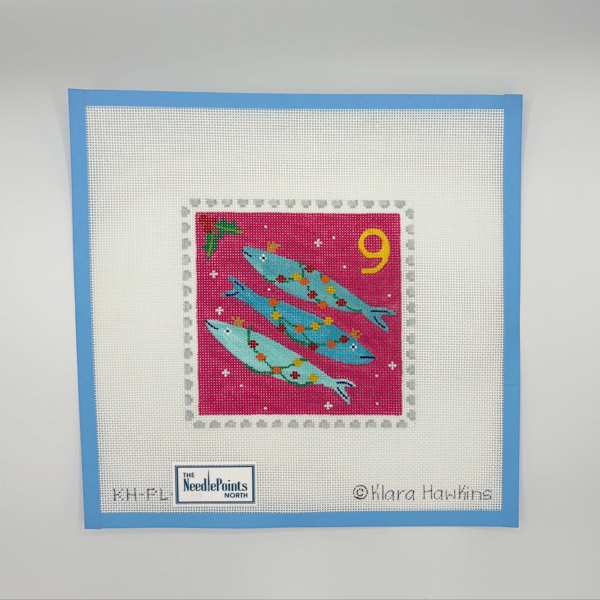 needlepoint design of three fish on a red square with a blue border, featuring the Needlepoint Factory logo.