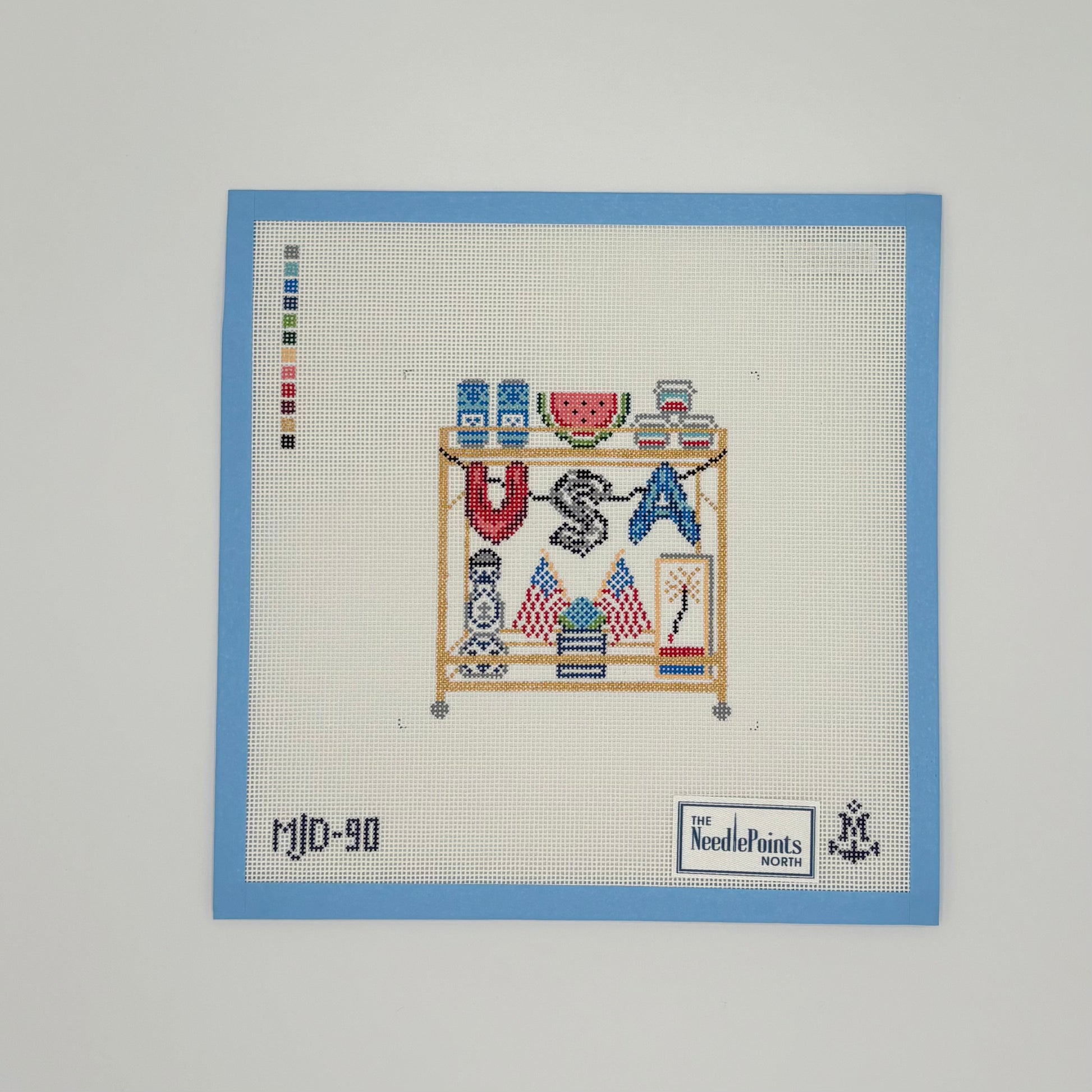 needlepoint piece with 'USA' and various symbols on a white background