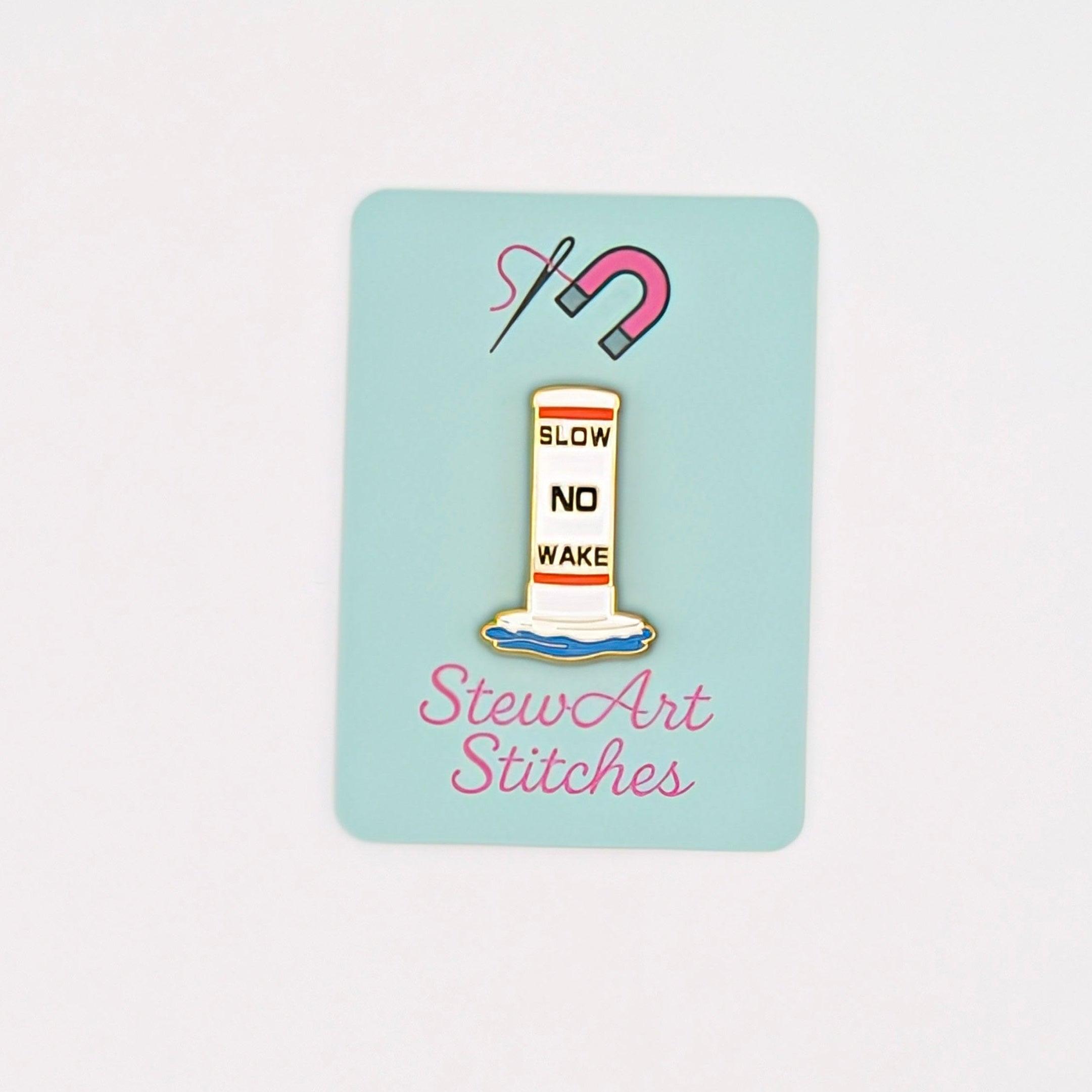 A small rectangular mint-blue sticker or card centered on a white background, featuring a sewing-themed illustration with a spool of thread, scissors, and the text 'StewArt Stitches'.