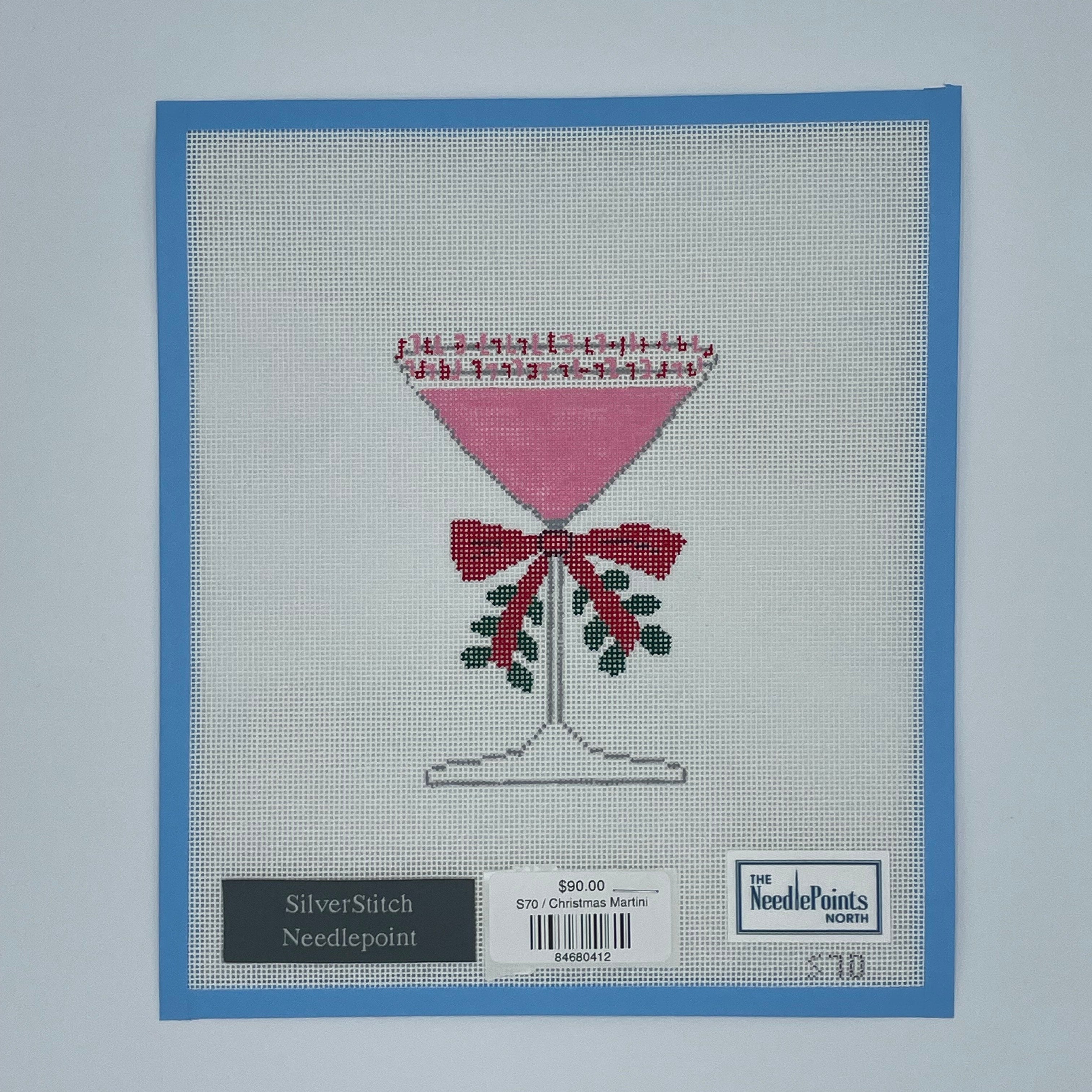 needlepoint design on fabric with a blue border and brand label.