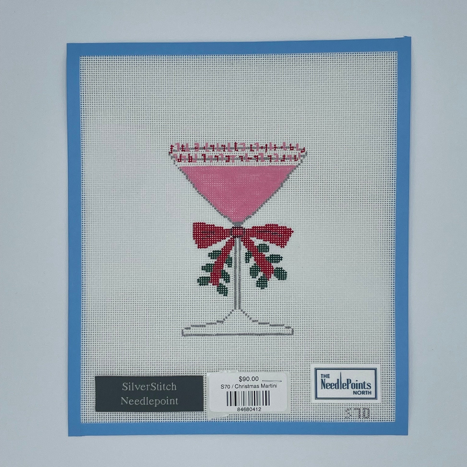 needlepoint design on fabric with a blue border and brand label.